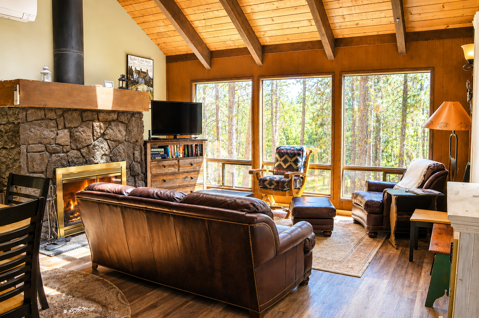 Picture yourself here: rich leather furnishings, glowing fireplace, soaring wood ceilings, and floor-to-ceiling windows framing tranquil forest views—your perfect mountain escape awaits.