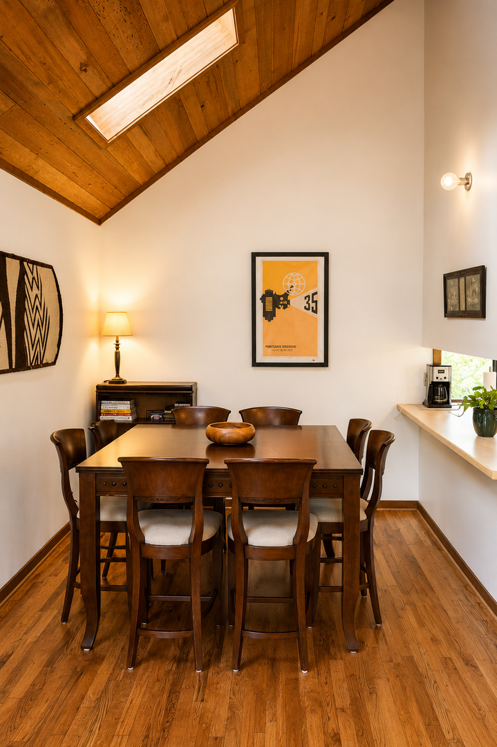 Gather around this inviting dining space with warm wood tones, soaring ceilings with a skylight, and a fully-equipped coffee station to start your mornings right.