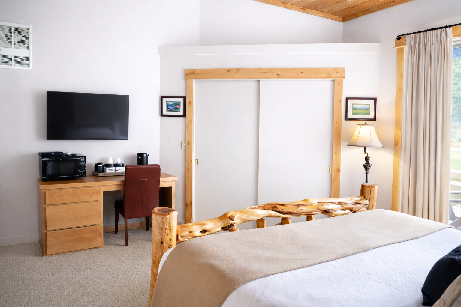 Your comfortable bedroom features rustic wood details, modern amenities, and a cozy workspace for the perfect mountain getaway.