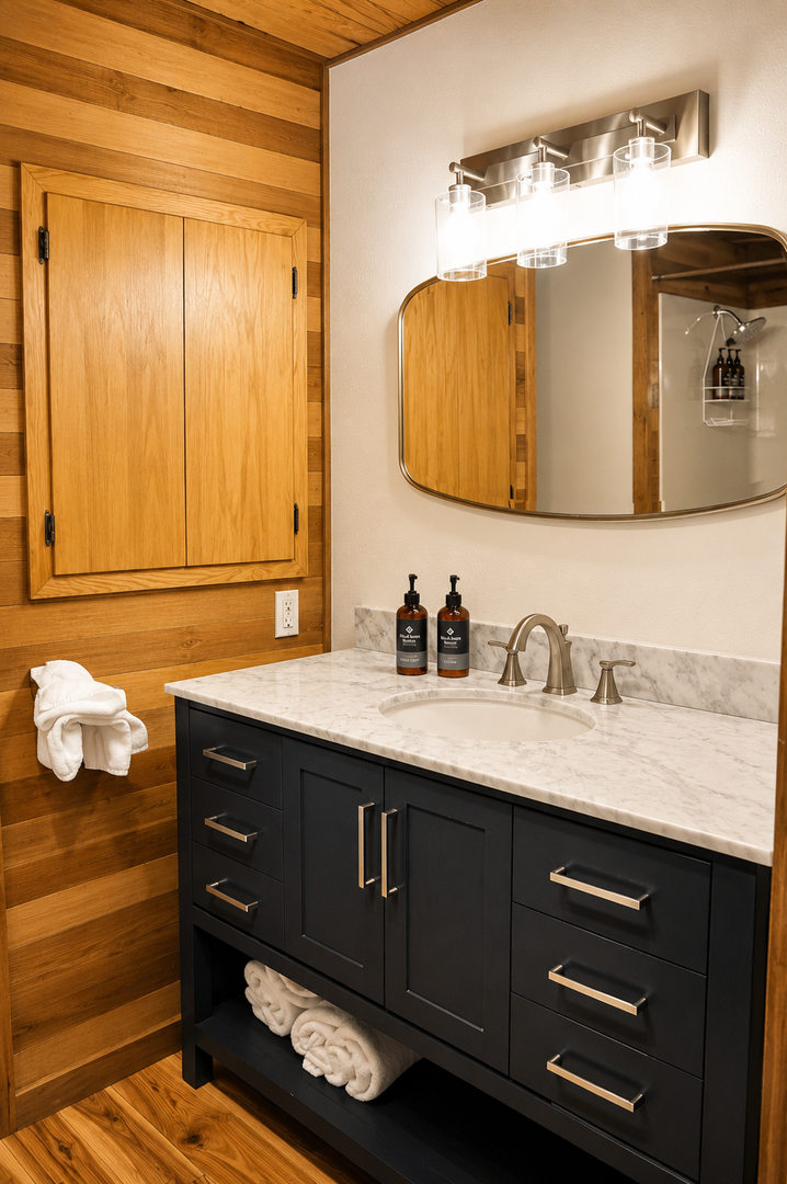 Your stylish bathroom blends warm wood tones with elegant marble countertops and modern fixtures. Fluffy towels and quality amenities await, making your morning routine feel like a spa experience.