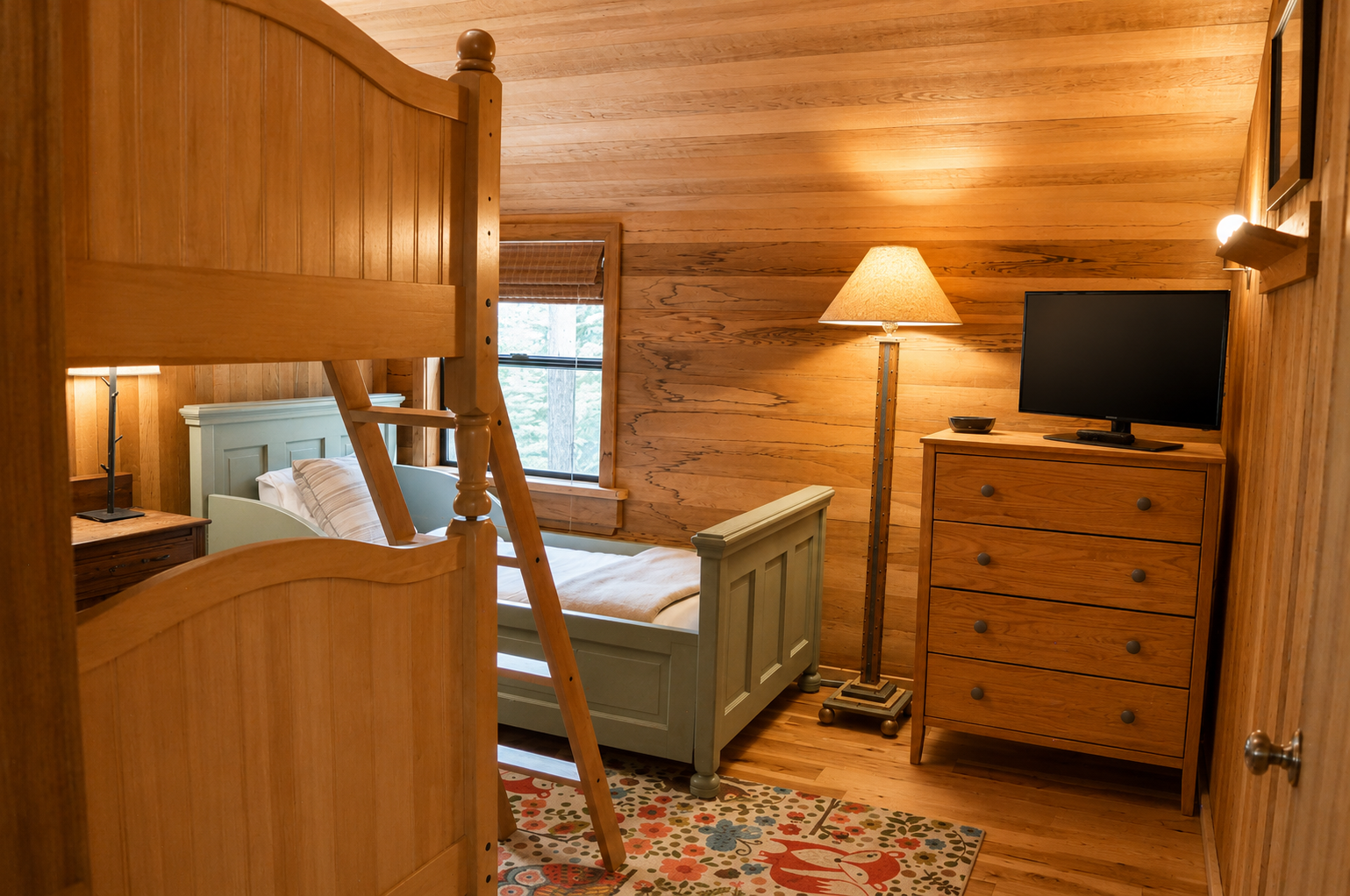 Cozy bedroom featuring warm wood paneling, bunk bed, twin bed, dresser with flat-screen TV, and charming natural light from the window—perfect for families or groups.