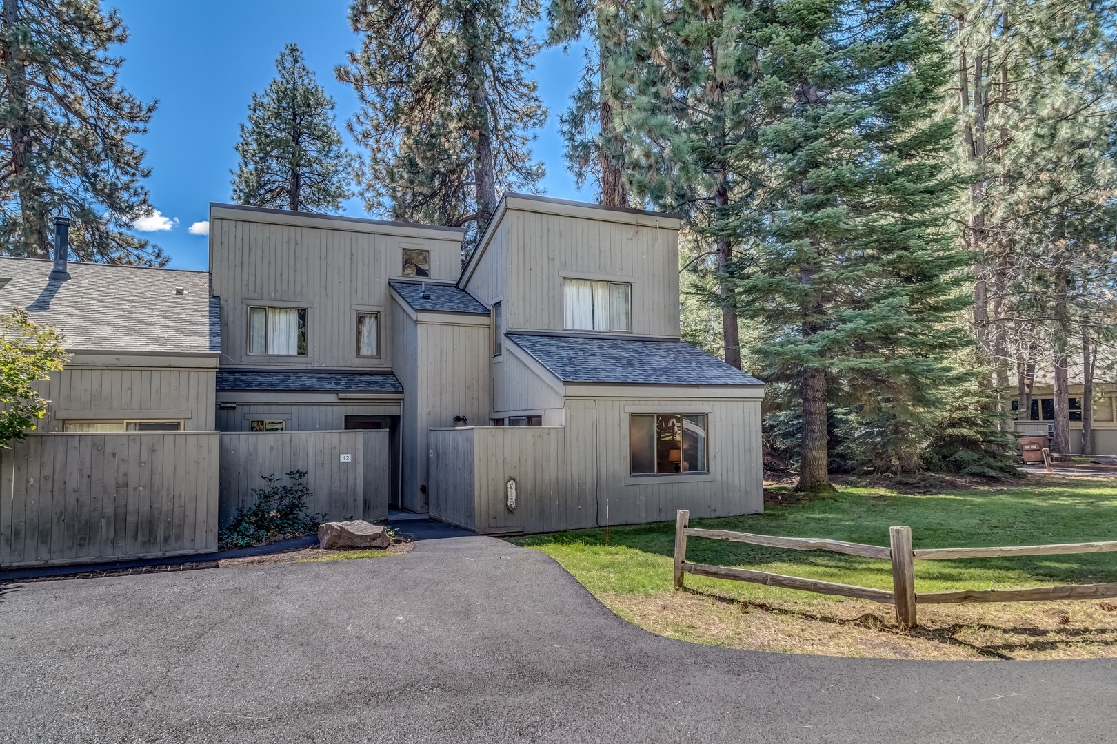 Modern mountain retreat nestled among towering pines with private driveway and parking for a peaceful forest getaway.