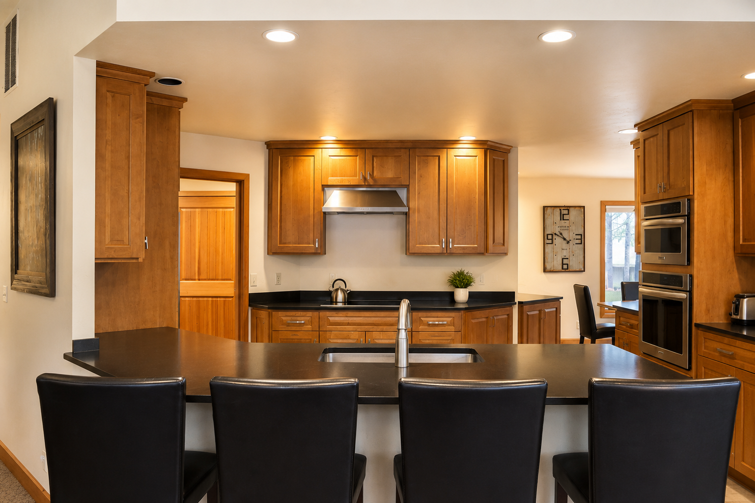 Your gourmet kitchen awaits with sleek dark countertops, rich wood cabinetry, and stainless steel appliances. Gather around the island for meals or conversation in this inviting space.