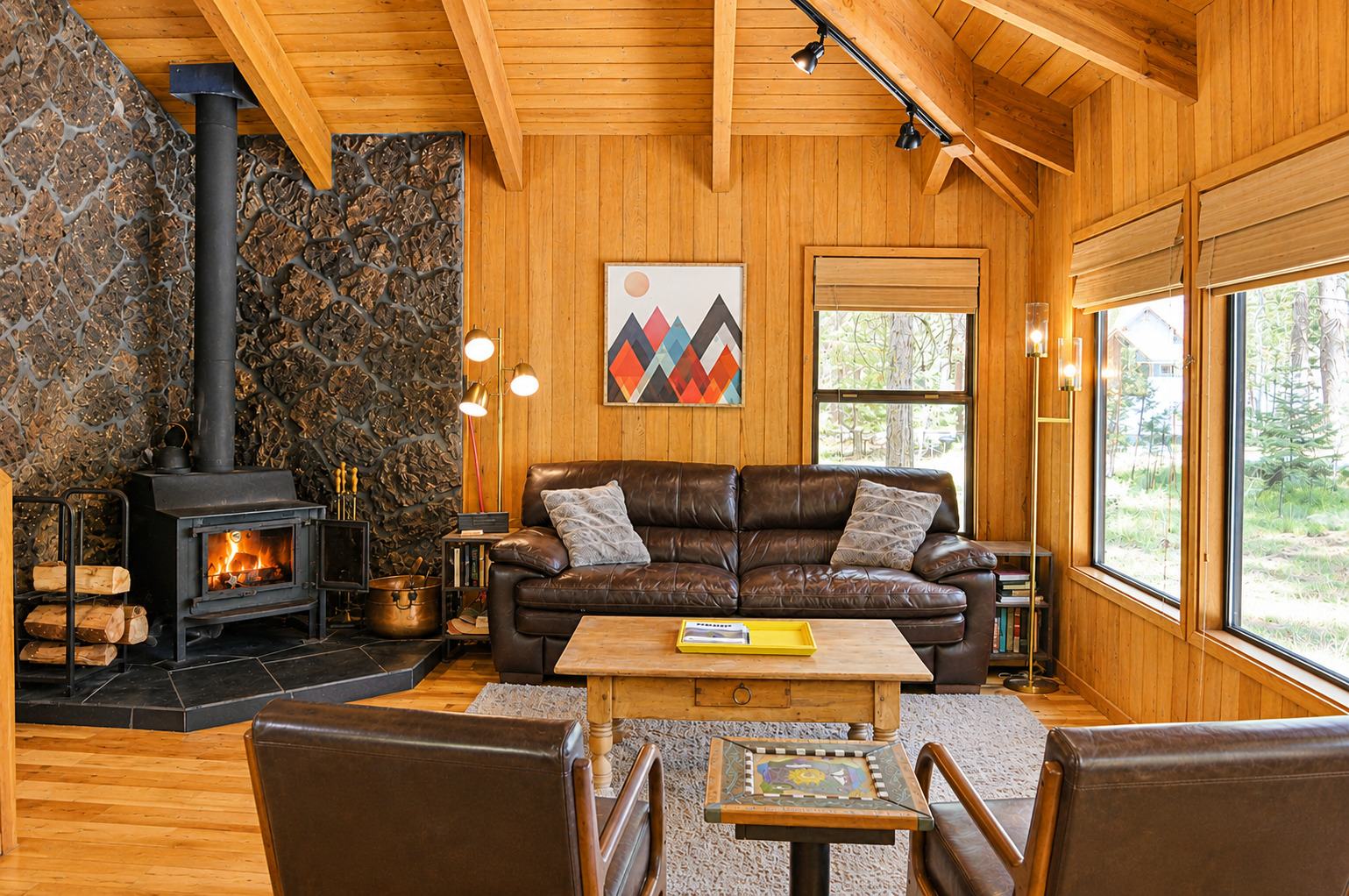 Warm up by your crackling fireplace in this inviting living space, where vaulted ceilings, plush leather seating, and forest views create your perfect retreat.