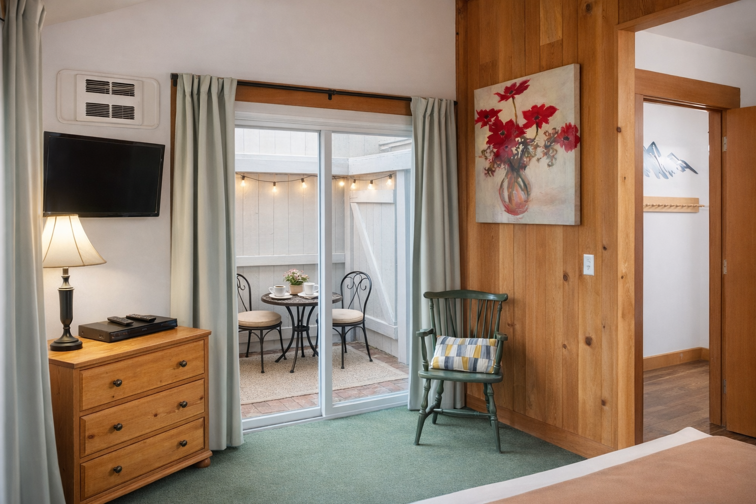 Relax in your charming room with warm wood accents, flat-screen TV, and private patio access for peaceful outdoor moments.