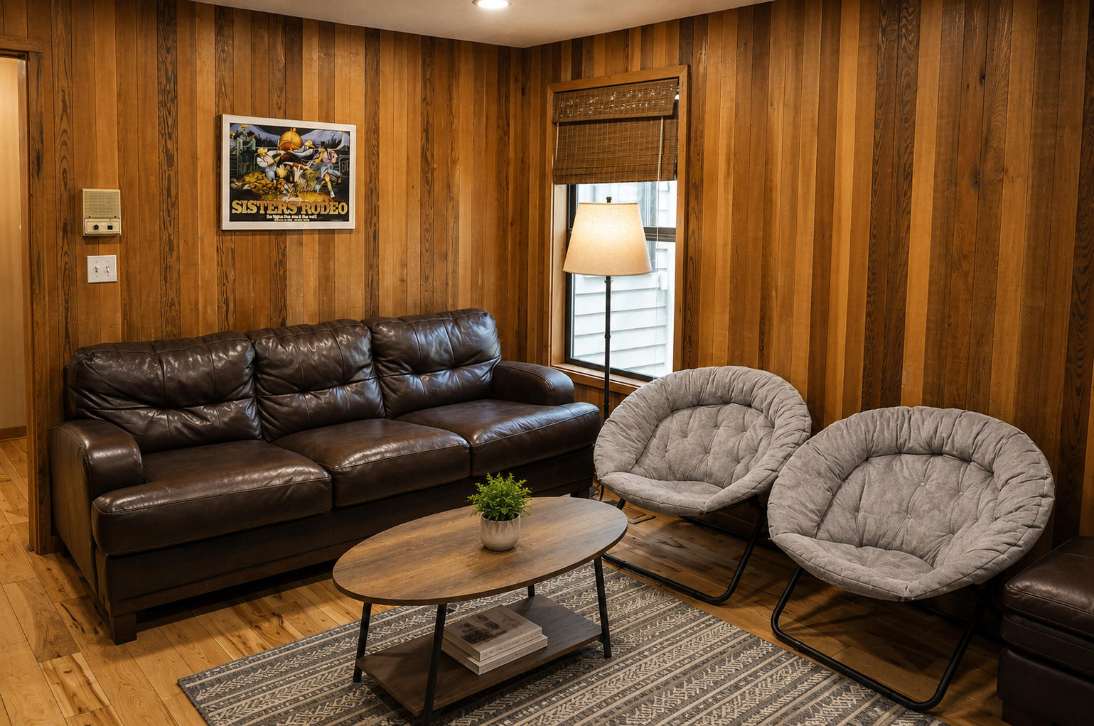 Sink into the plush leather sofa or curl up in one of the cozy papasan chairs, surrounded by warm wood paneling that creates a welcoming retreat for relaxation.