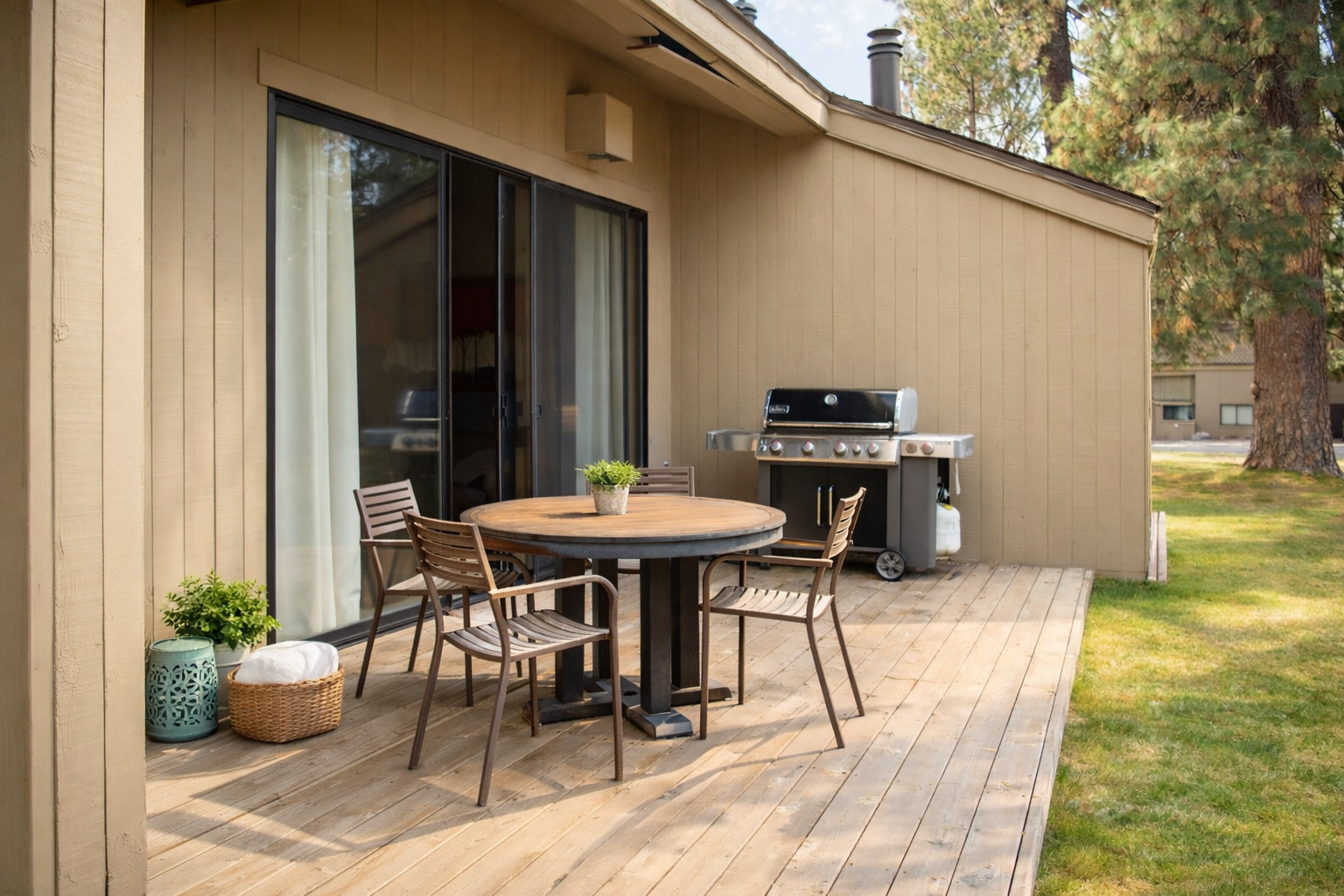 Gather around your private outdoor dining table for grilled favorites, then relax on this peaceful wooden deck overlooking lush green lawns.