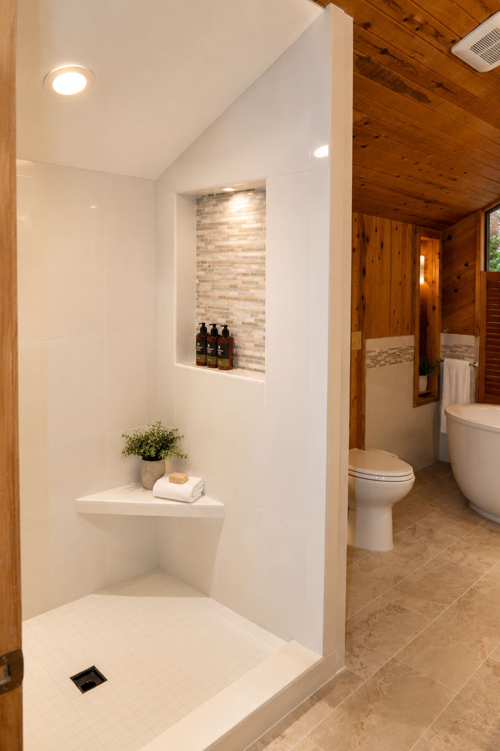 Step into your spa-like retreat with a sleek walk-in shower, warm wood accents, and thoughtful details that make your morning routine feel luxurious.