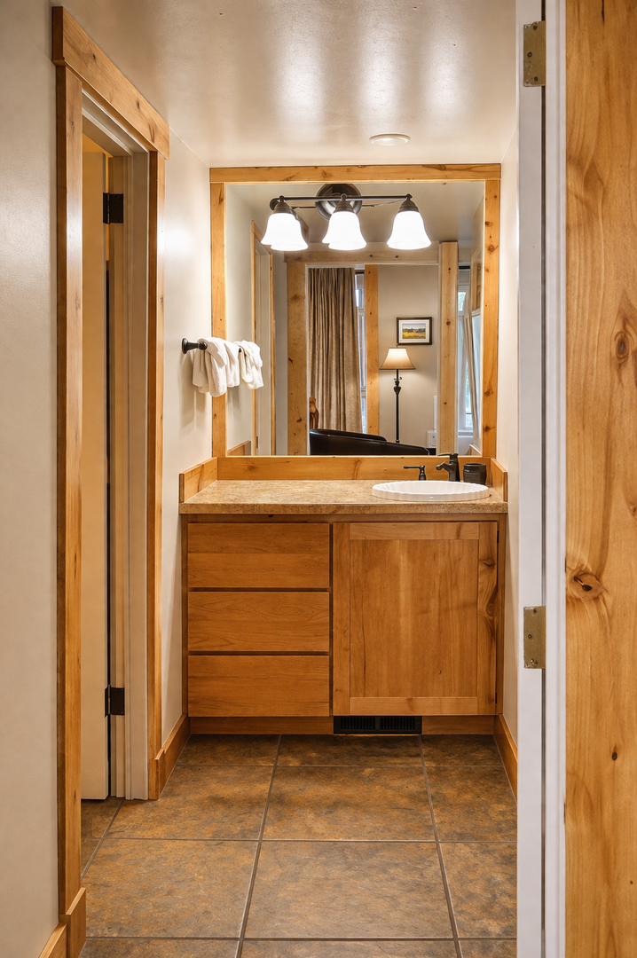 Refresh in your beautifully appointed bathroom with warm wood vanity, perfect lighting, and fresh towels waiting for you.