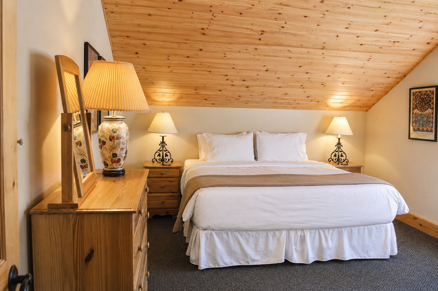 Unwind in your cozy retreat with warm wood ceilings, crisp white linens, and soft lighting that creates the perfect atmosphere for rest.