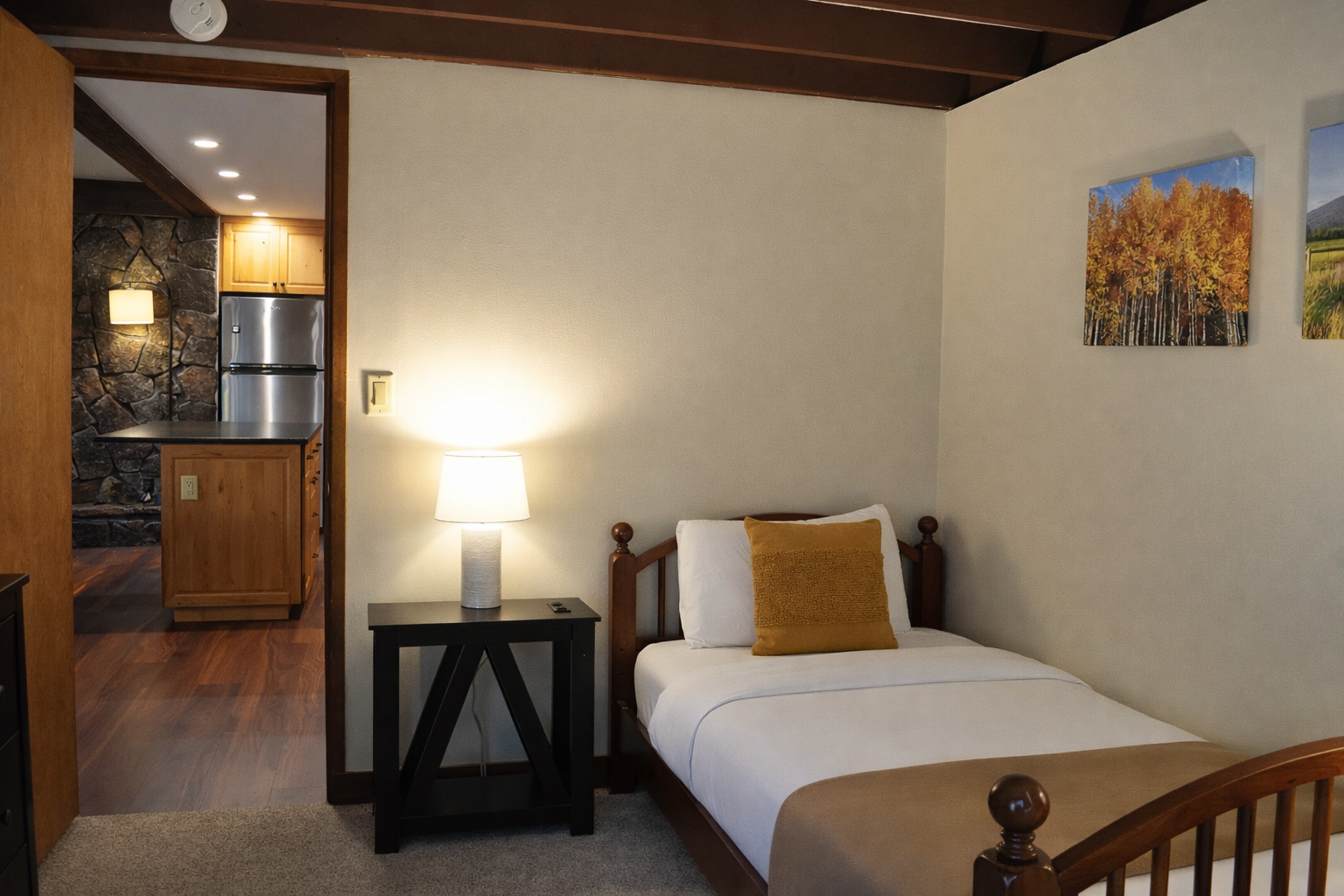 Unwind in your cozy bedroom with rustic wood beams overhead and a peaceful single bed perfect for restful nights.