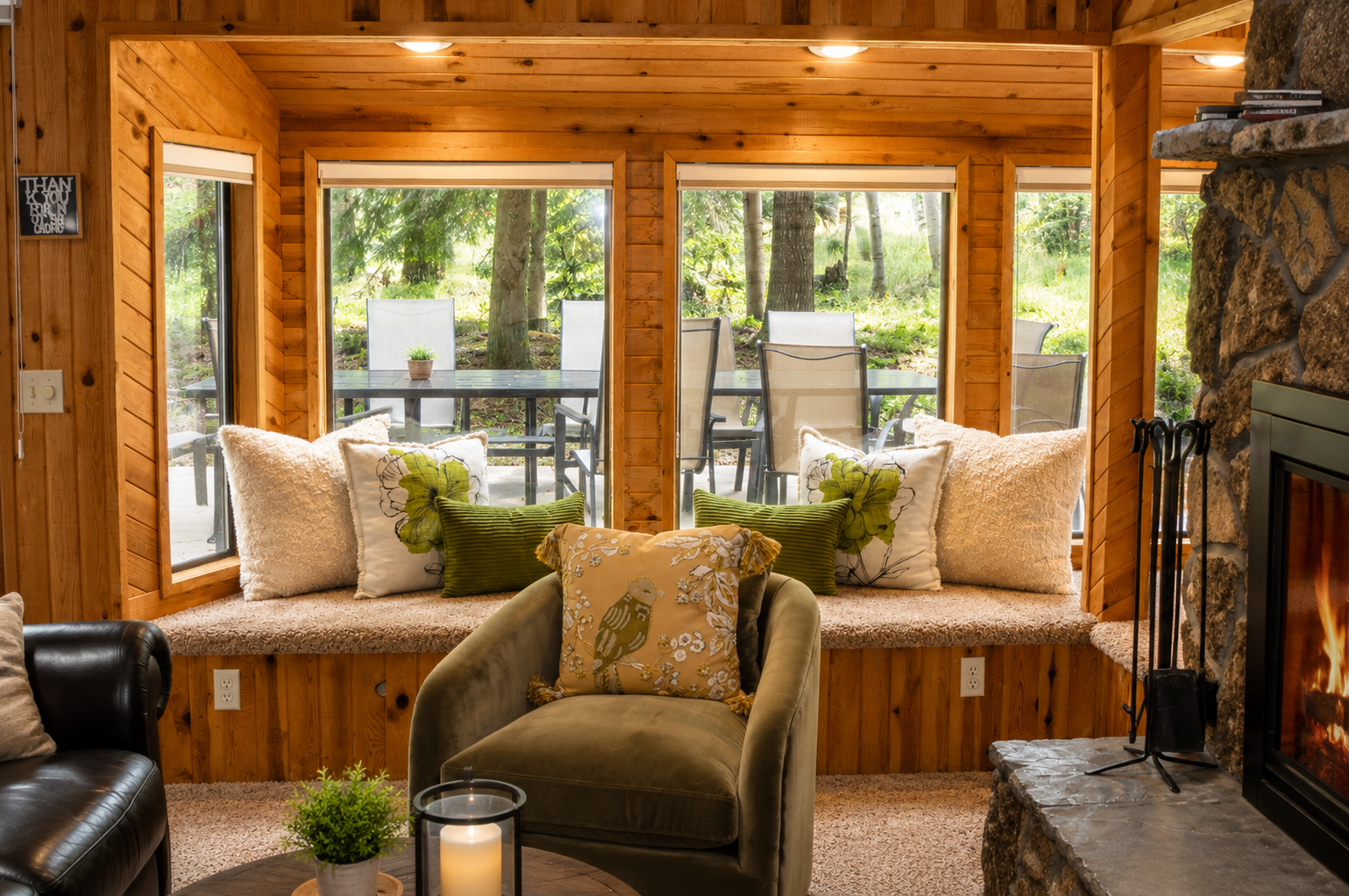 Sink into plush seating by the stone fireplace, surrounded by warm wood and natural light. Your cozy window nook overlooks peaceful forest views—perfect for morning coffee or unwinding.