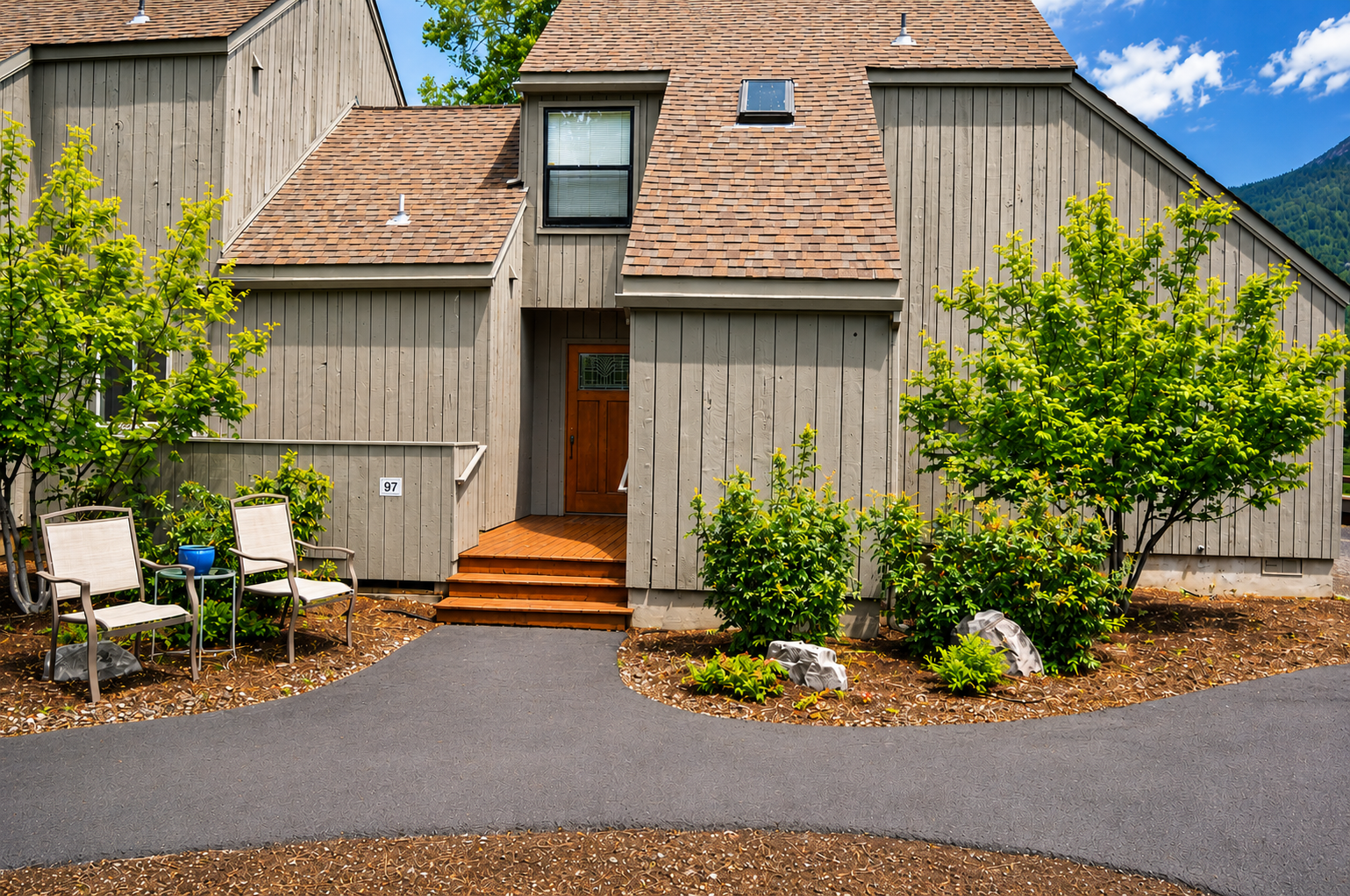 Mountain retreat nestled in greenery with private entrance and welcoming outdoor seating to enjoy the fresh alpine air and peaceful surroundings.