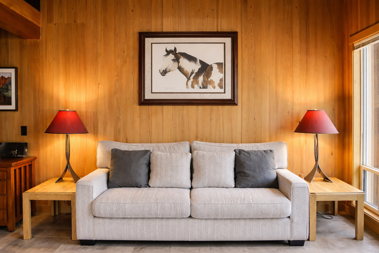 Sink into this cozy living room where warm wood paneling and soft lighting create your perfect retreat after exploring.