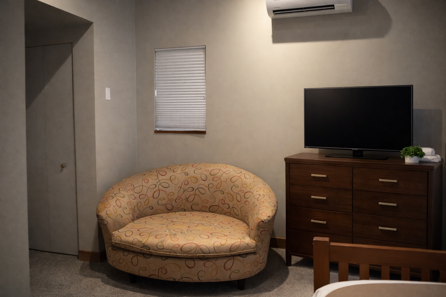 Unwind in your cozy living space with a plush round chair, entertainment center, and climate-controlled comfort for relaxing evenings.