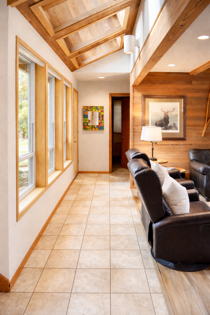 Unwind in your private living space with exposed beam ceilings and leather recliners facing peaceful garden views.