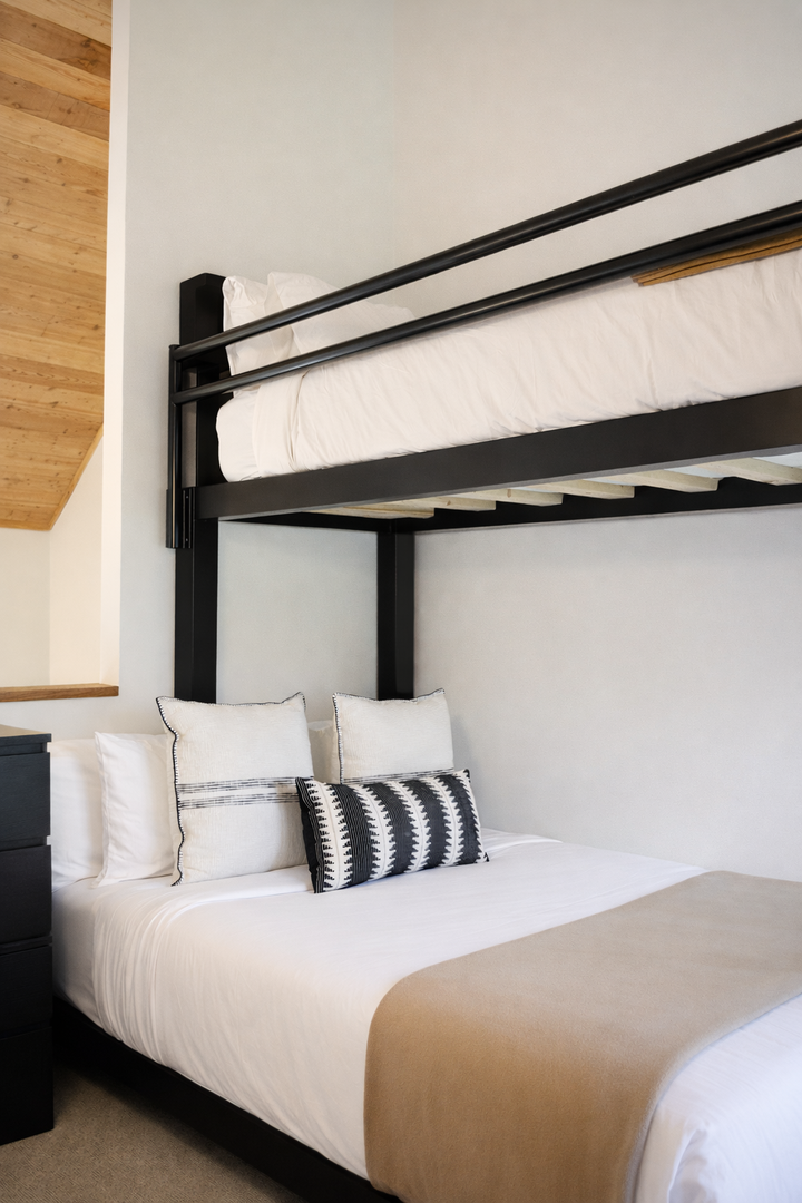 Rest beneath exposed wooden beams in your stylish sanctuary, where modern comfort meets architectural charm with crisp linens and designer touches.