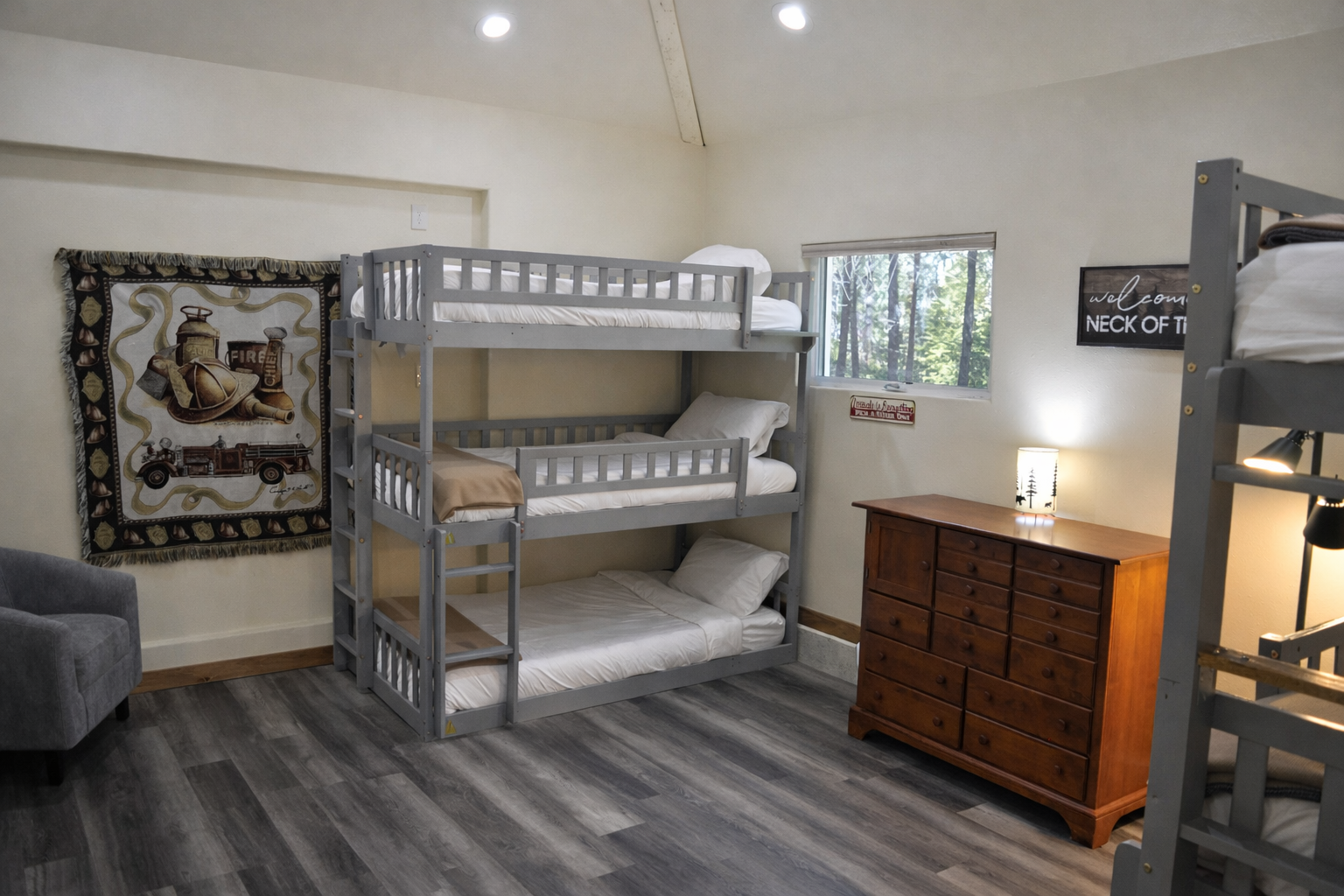Sleep soundly in your cozy bunk room with comfortable beds, dresser storage, and forest views through the window.