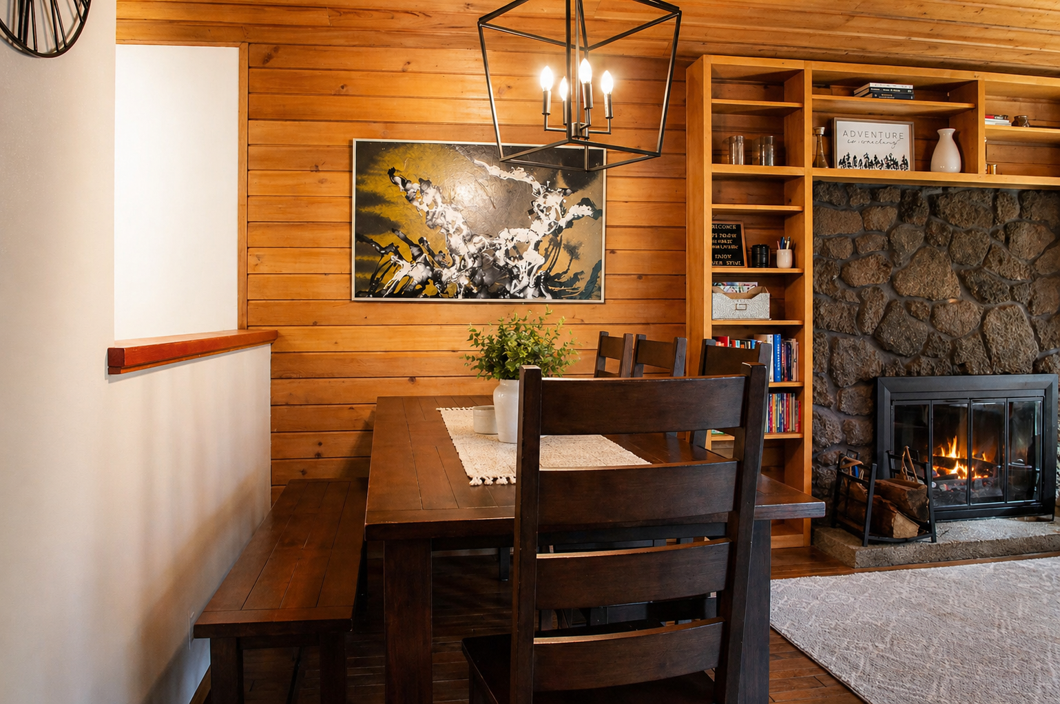 Gather around your cozy dining nook where warm wood meets crackling flames, creating the perfect spot for memorable meals.