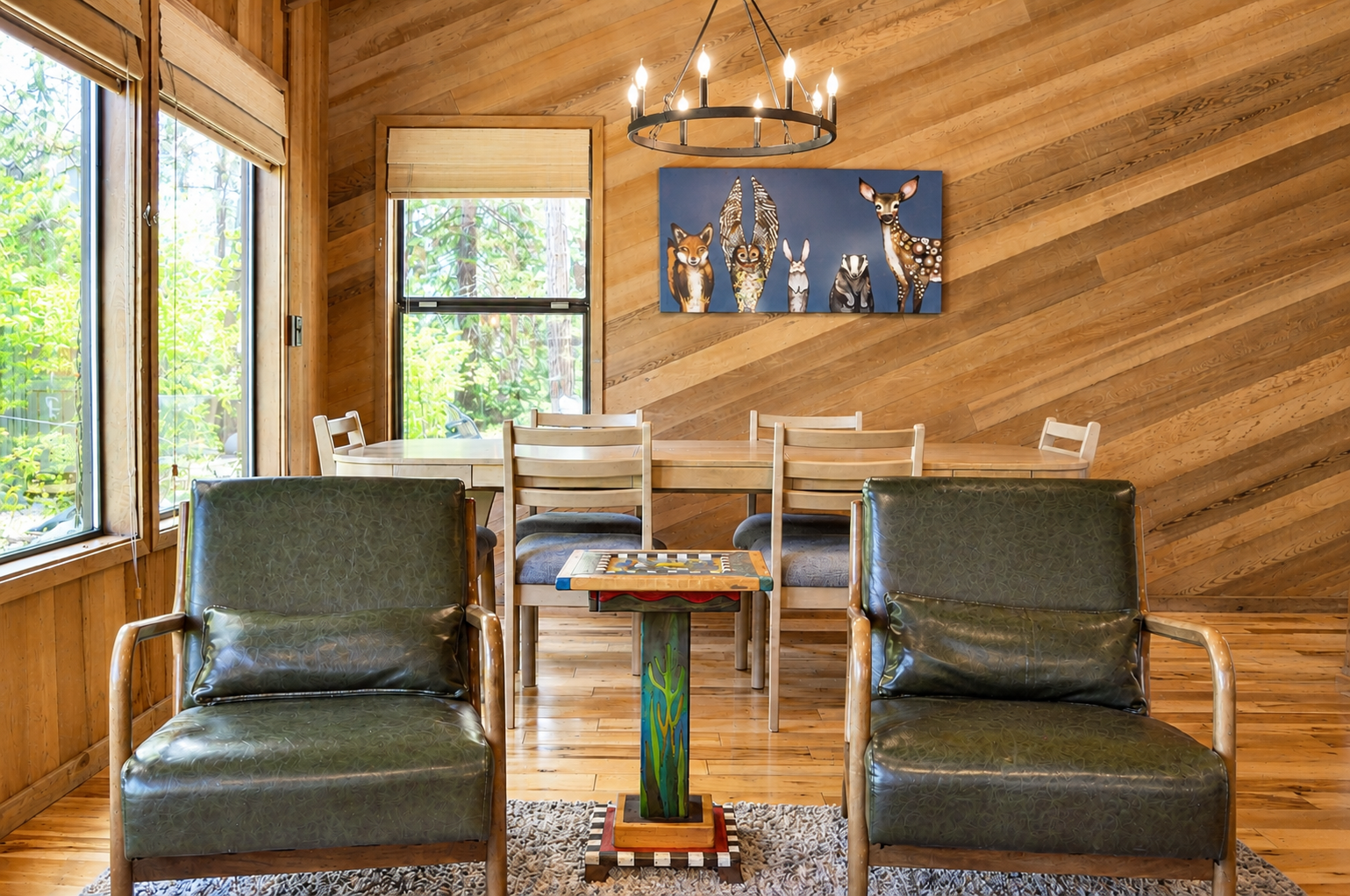 Gather around the rustic dining table where warm wood tones and playful woodland art create your perfect mountain retreat. The inviting seating area offers cozy comfort for games and conversation.