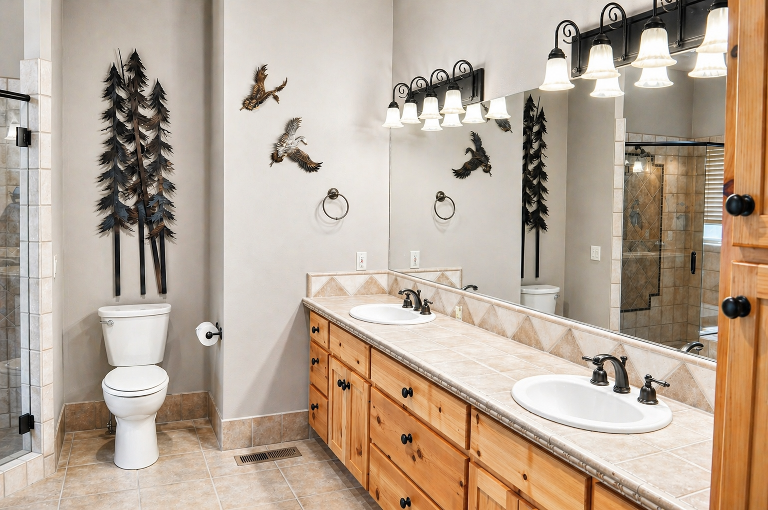 Freshen up in your spacious bathroom featuring dual sinks, rustic wood vanity, and charming wildlife décor that creates a cozy mountain retreat atmosphere.