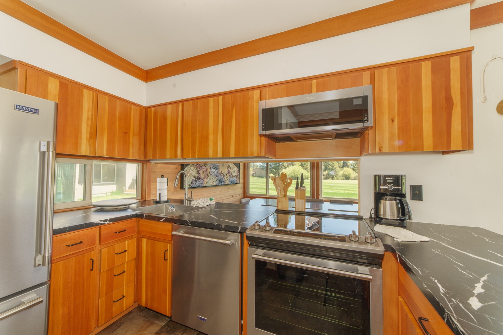 Your fully equipped kitchen features warm wood cabinetry, sleek countertops, and modern appliances—perfect for preparing memorable meals during your stay.
