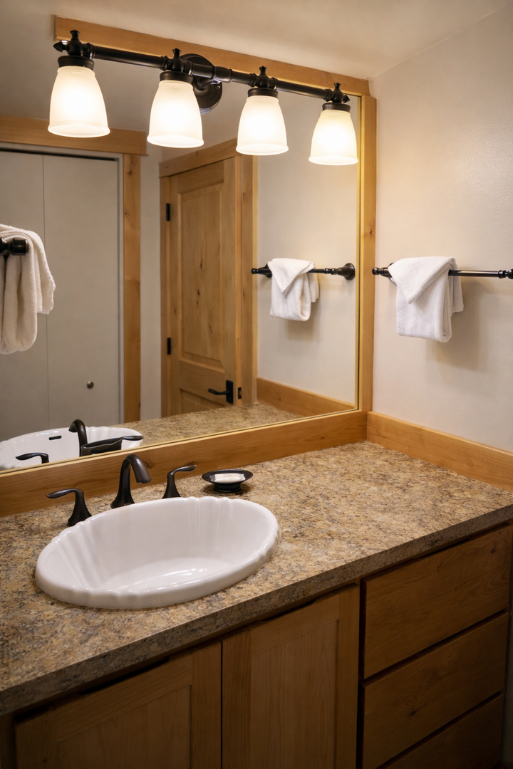 Refresh in your elegant bathroom featuring granite countertops, warm wood cabinetry, and perfect lighting for your morning routine.