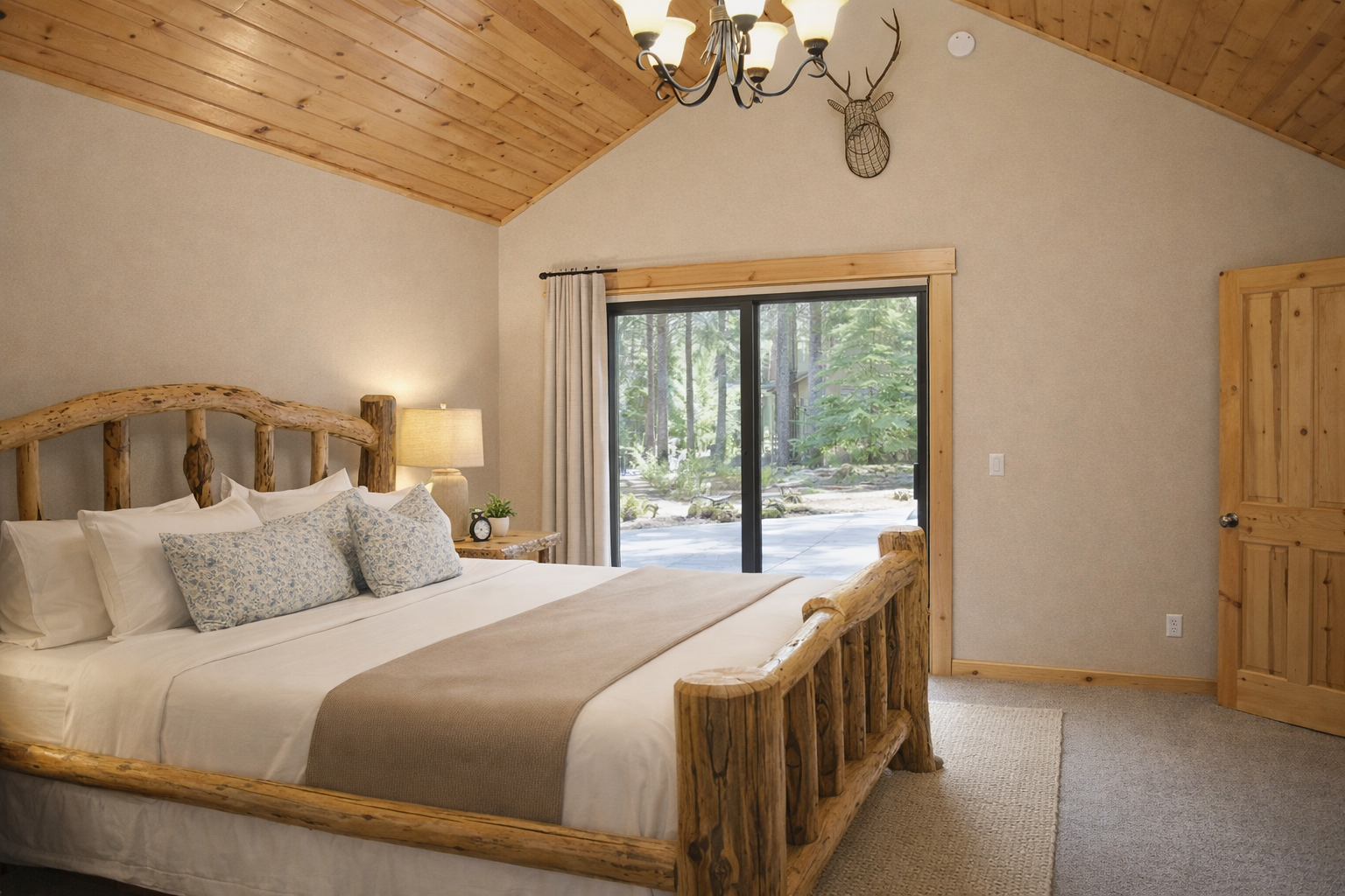 Unwind in your cozy bedroom with rustic log furniture and forest views through sliding doors to your private deck.