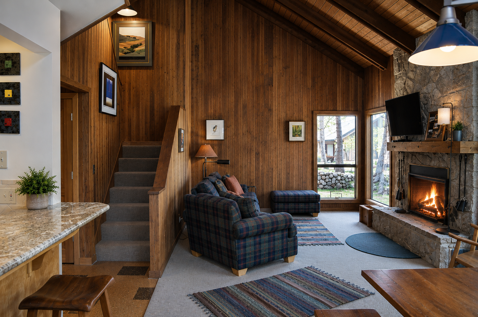 Cozy up in your spacious living room with vaulted wood ceilings, a crackling stone fireplace, and big windows framing peaceful outdoor views—perfect for unwinding after a day of adventure.