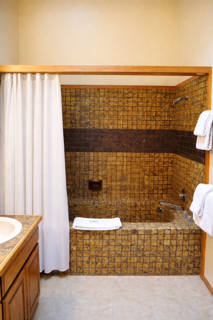 Unwind in your stunning mosaic-tiled bathroom, where golden tiles create a luxurious spa-like atmosphere for your perfect soak.