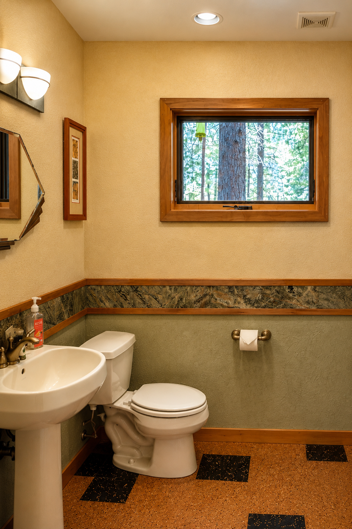 Your private bathroom offers warm wood accents, natural forest views through the window, and modern fixtures for a comfortable, peaceful retreat during your stay.