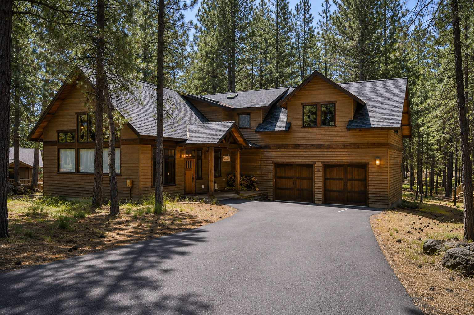 This spacious mountain retreat sits nestled among towering pines, featuring warm wood siding, a two-car garage, and welcoming front porch—a peaceful forest setting for arrival.