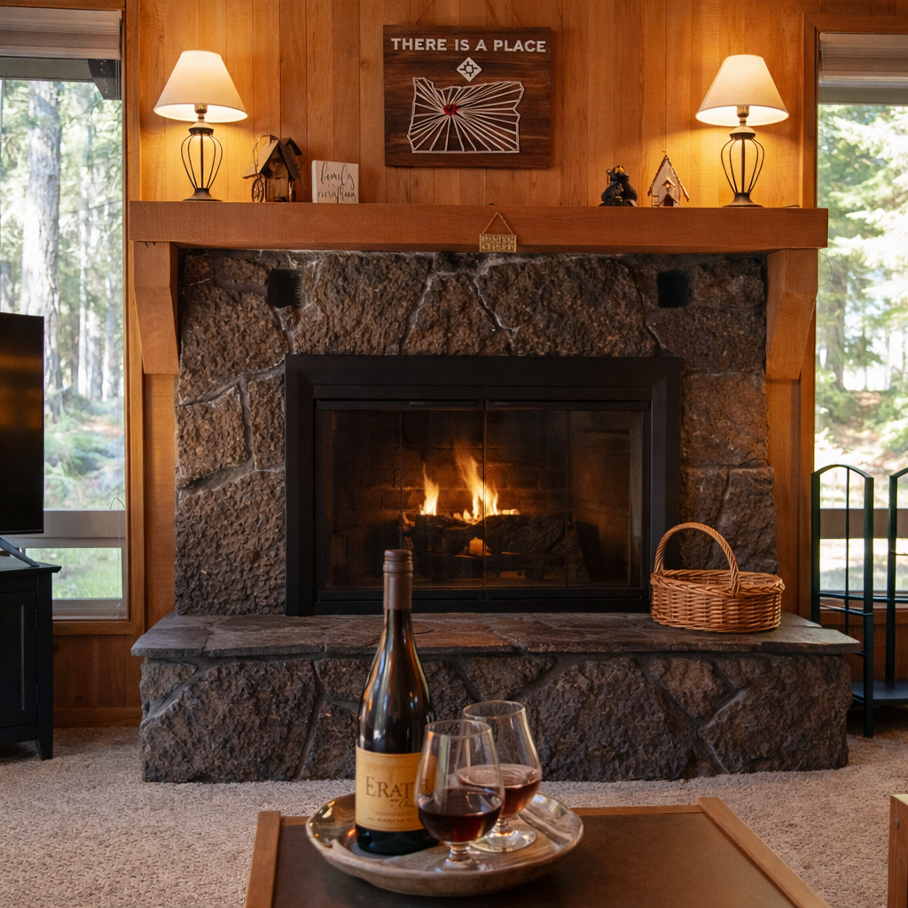 Cozy up by your stone fireplace with a glass of wine, surrounded by warm wood paneling and forest views.