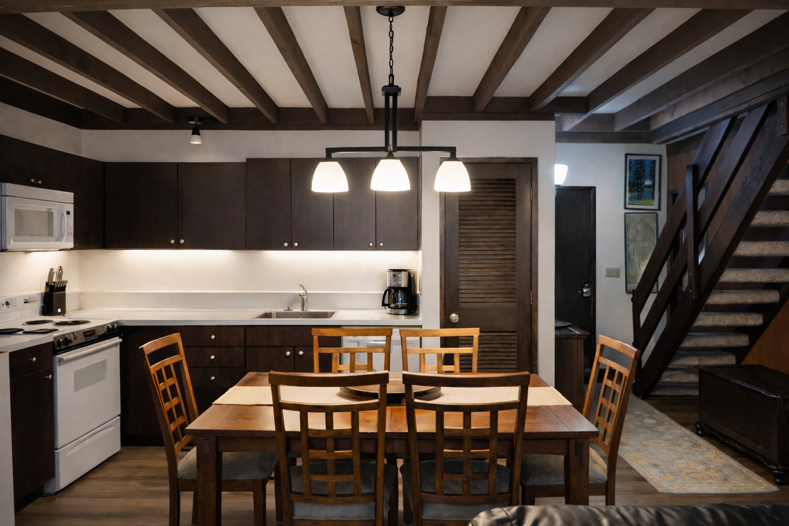 Your open-concept kitchen and dining space features rustic exposed beams, modern appliances, and warm wood furnishings for memorable meals together.