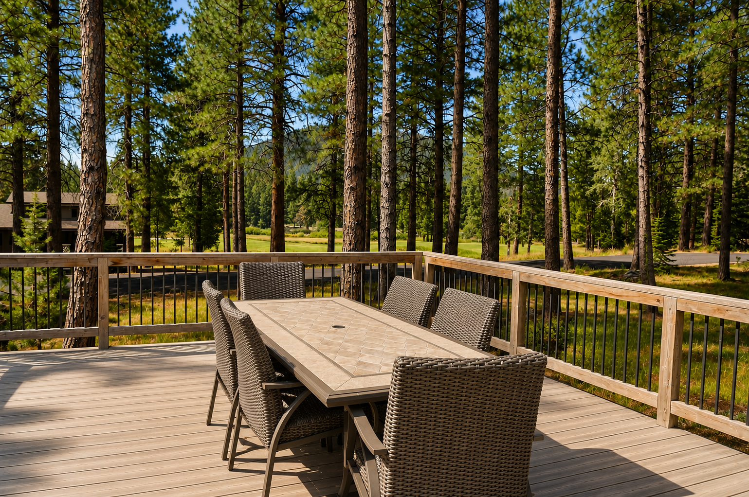 Scenic deck with dining setup offers views of towering pines and open meadow, perfect for morning coffee or evening meals surrounded by nature.