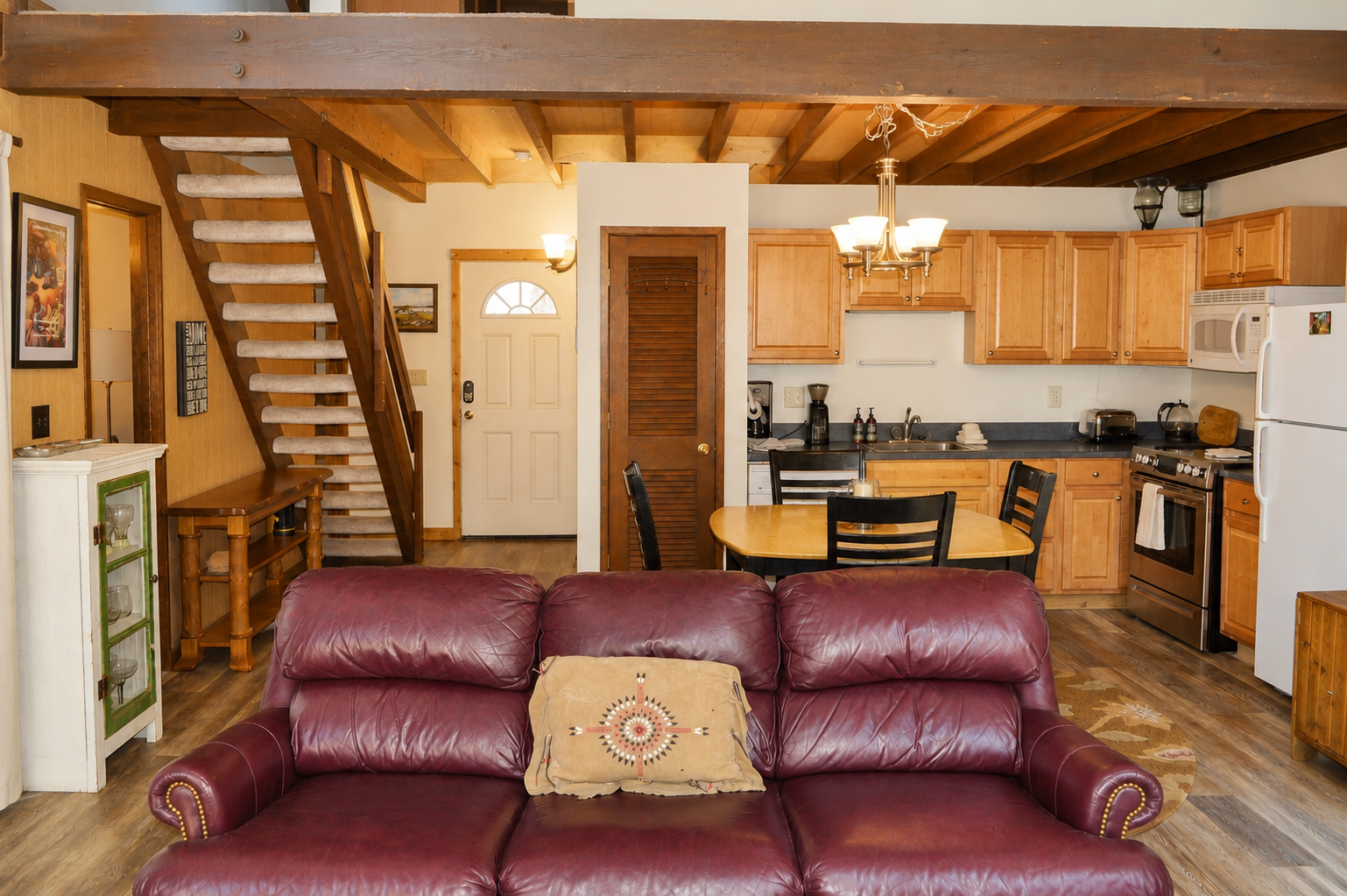 Relax on the plush leather sofa in your open-concept cabin, where rustic wood beams and a full kitchen invite you to cook, dine, and unwind in cozy mountain style.