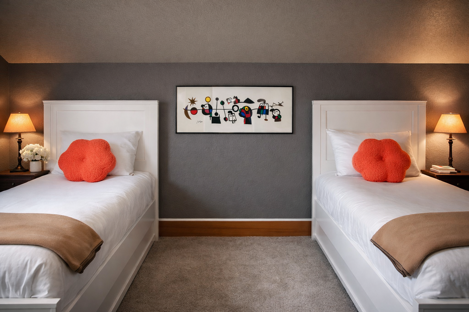 Your stylish twin bedroom features comfortable beds with vibrant coral accents and playful artwork, perfect for restful nights after exploring.