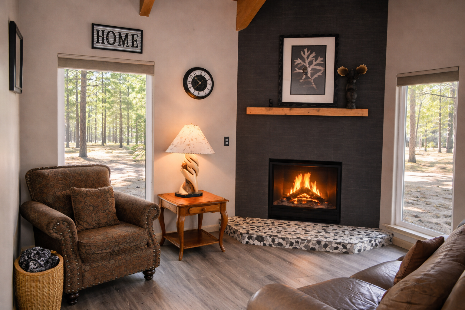Sink into the plush armchair by your crackling fireplace, where warm light and forest views create the perfect retreat for evening relaxation.