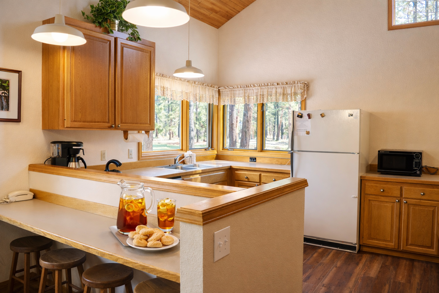 Your fully-equipped kitchen welcomes you with warm wood tones and forest views, perfect for brewing morning coffee and preparing meals together.