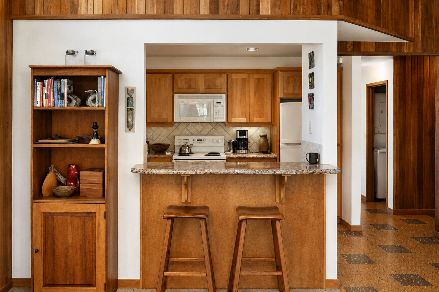 Your open kitchen welcomes you with warm wood tones, granite counters, and full appliances—perfect for brewing morning coffee or whipping up meals at the breakfast bar.