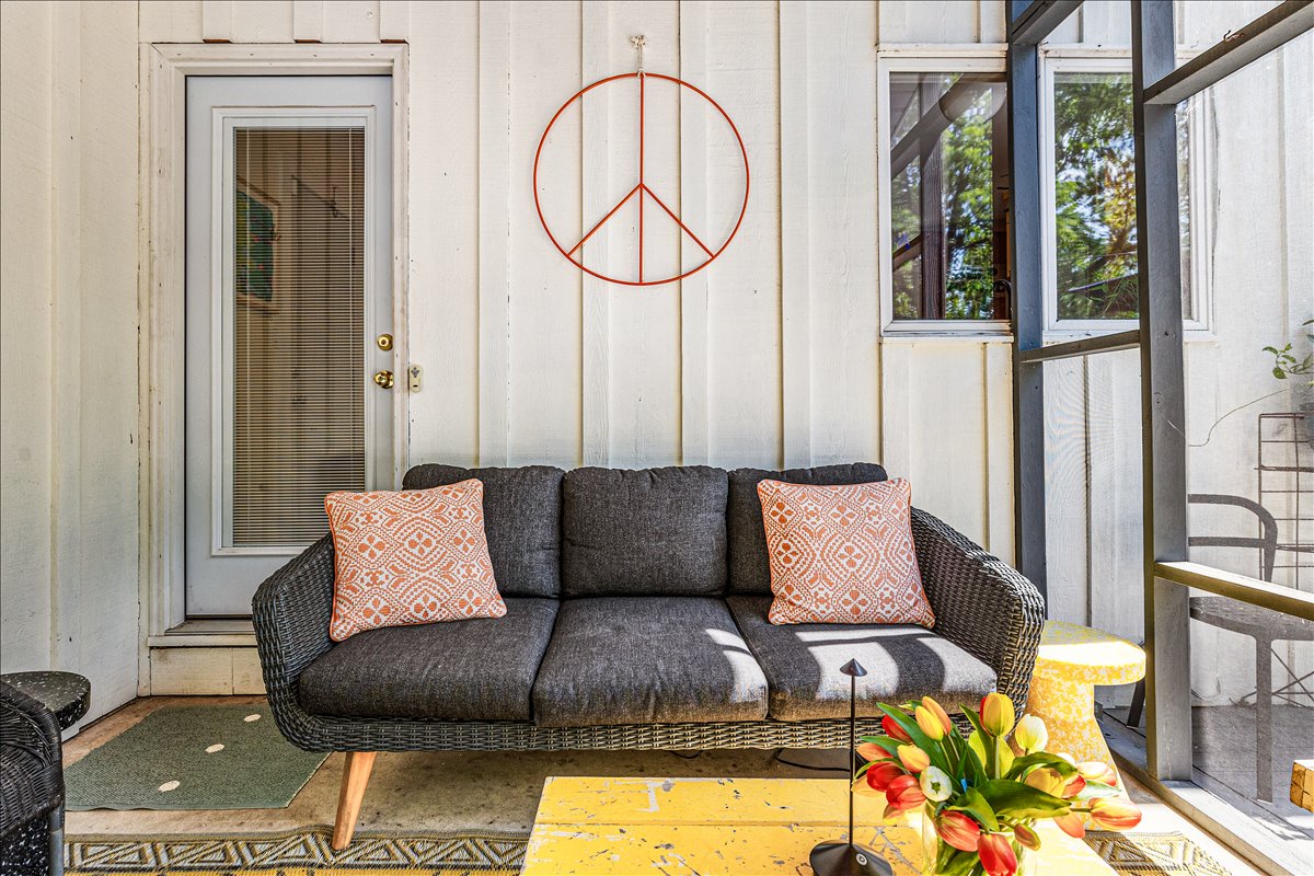 Relax on your private enclosed porch with comfortable seating, natural light streaming through windows, and peaceful vibes.