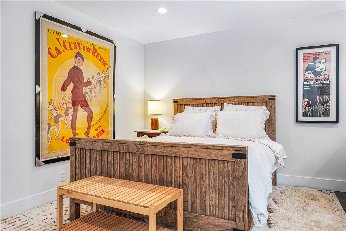Drift off to sleep in your charming wooden bed surrounded by vintage French posters and artistic touches that create a cozy, cultured atmosphere.
