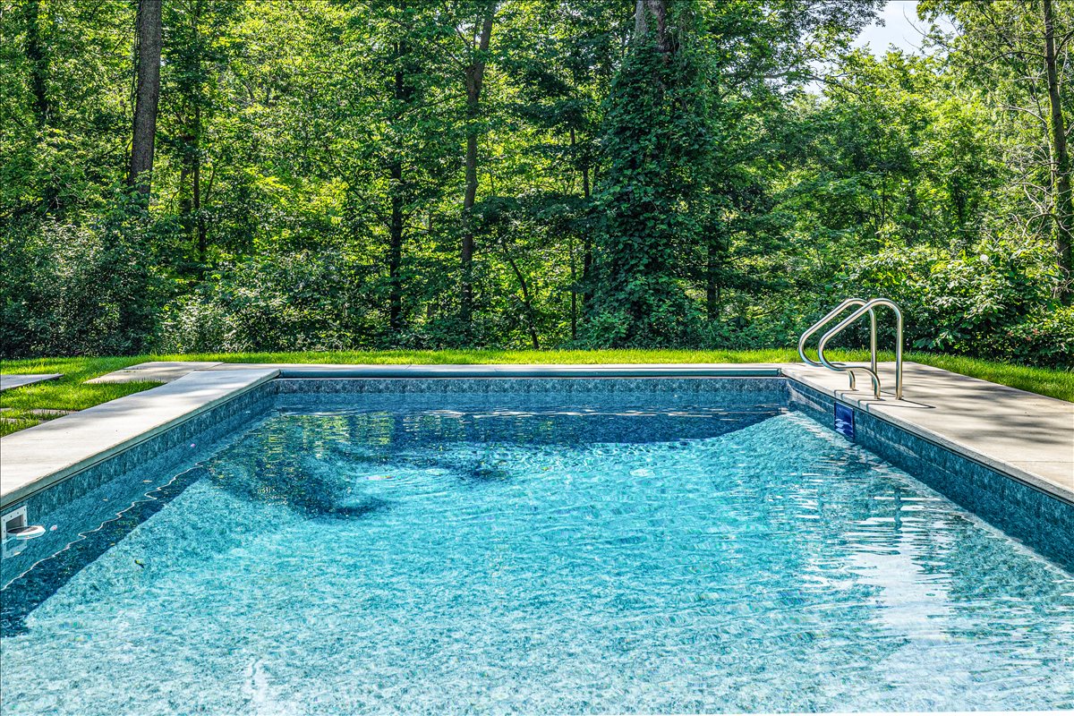 Dive into crystal-clear waters surrounded by lush forest. Your private pool oasis awaits with sparkling blue depths and peaceful natural surroundings.