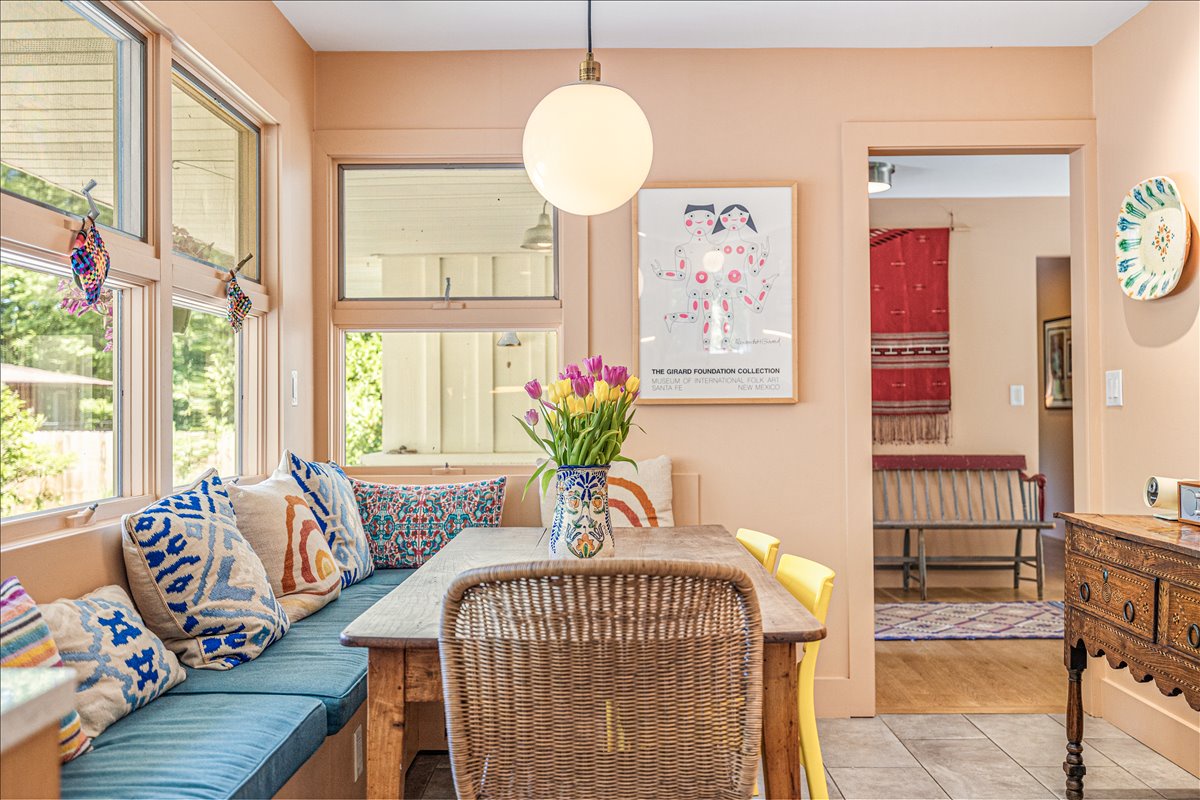 Settle into this bright breakfast nook where morning coffee feels magical with colorful pillows and fresh tulips welcoming each day.