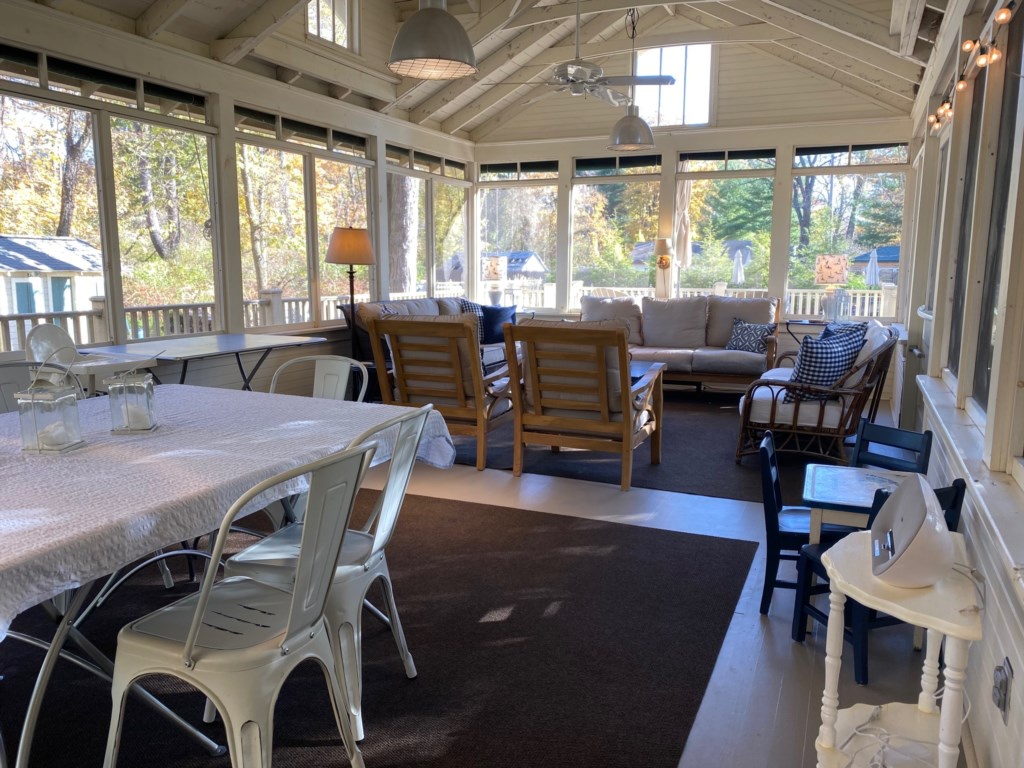 Separate dining and seating spaces on screened porch.