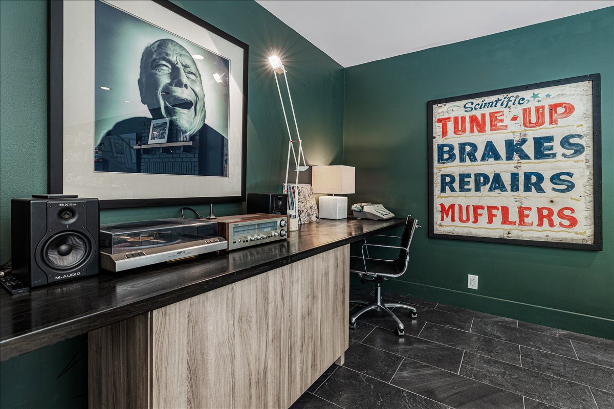 Your productive workspace awaits with vintage-inspired art, quality sound system, and modern desk setup for remote work or creative projects.
