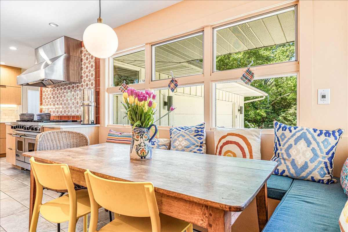 Gather around this charming dining nook where colorful pillows and fresh tulips create the perfect spot for morning coffee and evening conversations.