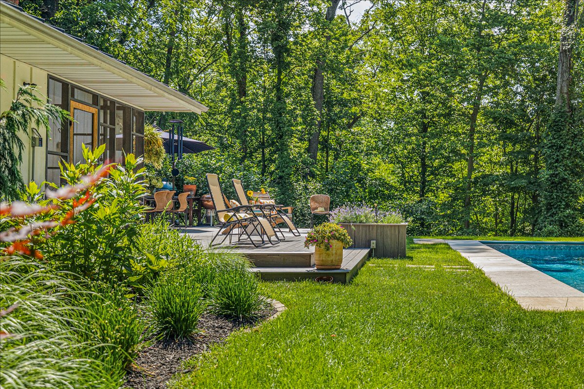 Step onto your private deck where lounge chairs await among lush gardens, with a sparkling pool just steps away for ultimate relaxation.
