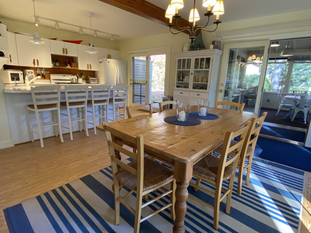 Dining table with screened porch beyond.