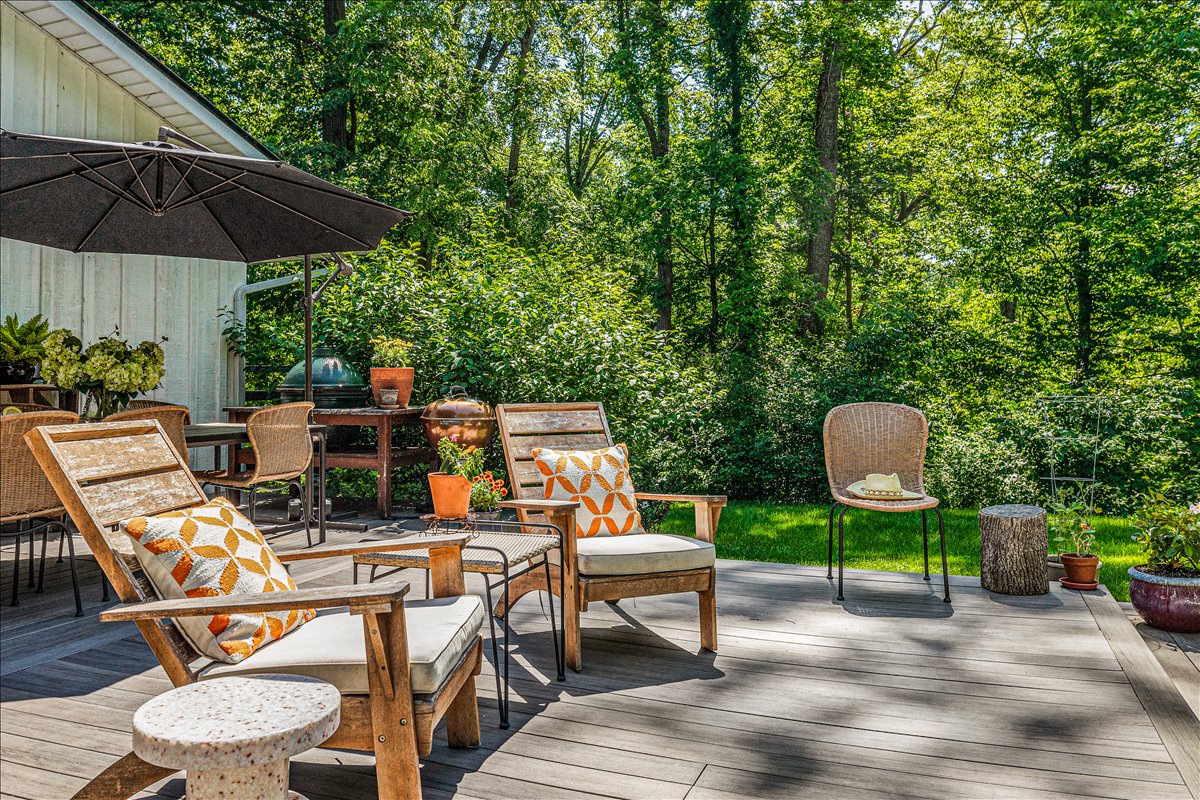 Unwind on your private deck surrounded by lush forest canopy, where comfortable seating and shade invite peaceful mornings with coffee.